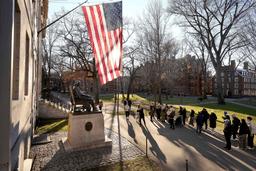 People take photos near a John Harvard statue, left, on the Harvard University campus, Jan. 2, 2024, in Cambridge, Mass. (AP Photo/Steven Senne, File)